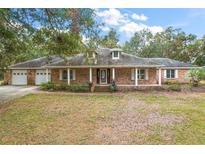 Brick ranch house with attached two-car garage and large yard at 34620 Galla Rd, Fruitland Park, FL 34731