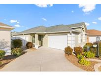 Single-story house with attached garage, landscaping, and a paved driveway at 893 Parrish Pl, The Villages, FL 32163