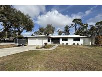Charming single-story home with white exterior, attached garage, and mature trees at 4060 Lake Marianna Dr, Winter Haven, FL 33881
