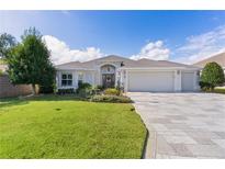 Single-story home with a three-car garage and landscaped yard at 747 Bradford Loop, The Villages, FL 32163