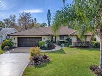 Single-story home with a well-maintained lawn and attached garage at 102 Cedar Way, Yalaha, FL 34797