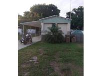 Front exterior of a single-Gathering home with a carport and landscaped yard at 12141 Lake Pines Rd, Leesburg, FL 34788