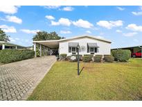 Charming single-story home with a paved driveway and landscaped yard at 1715 Lilly Ln, Lady Lake, FL 32159
