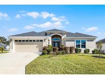 One-story house with a two-car garage and well-maintained lawn at 11415 Roma Rd, Oxford, FL 34484