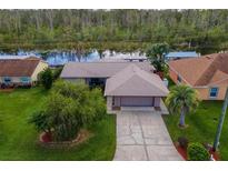 Single-story home with water access and lush landscaping at 13340 Country Club Dr, Tavares, FL 32778