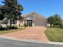 Single-story home with brick paver driveway and well-manicured landscaping at 1805 Feliciana Ter, The Villages, FL 32162