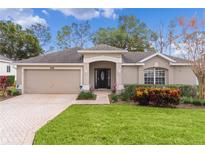 Single-story house with a two-car garage and well-manicured lawn at 3614 Kingswood Ct, Clermont, FL 34711