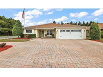 Well-maintained house with a paved driveway and landscaped yard at 5312 Galley Way, Oxford, FL 34484