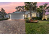 Attractive single-story home with paver driveway and landscaping at 10282 Julia Isles Ave, Oxford, FL 34484