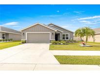 Single-story home with gray siding, two-car garage, and landscaped yard at 16178 Se 104Th Ter, Summerfield, FL 34491