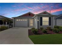 Gray house with red accents and a two-car garage at 5820 Bamboo Ave, The Villages, FL 32163