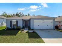 One-story home with gray siding, white garage door, and landscaped lawn at 1109 Catskill Dr, Haines City, FL 33844