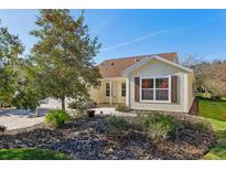 Side view of a house showcasing its landscaping and windows at 2876 Manor Downs, The Villages, FL 32162