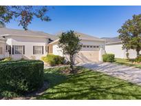 Well-maintained house with a two-car garage and lush lawn at 1018 Green Gate Blvd, Groveland, FL 34736