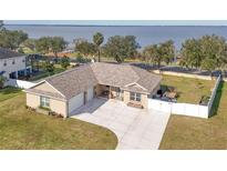 Single-story home with lake view, fenced yard, and two-car garage at 3219 Landing Vw, Tavares, FL 32778