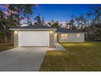 One-story home with a single-car garage and landscaped lawn at 5891 Sw 138Th Ter, Ocala, FL 34481