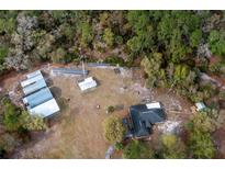 Aerial view of home with detached structures and solar panels at 12359 Ne Highway 314, Silver Springs, FL 34488