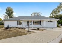 White single-story house with attached garage and landscaped yard at 6482 Sw 81St St, Ocala, FL 34476