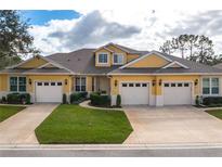 Two-story yellow home with three-car garage and landscaping at 3017 Mission Lakes Dr, Lakeland, FL 33803