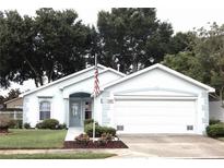Charming single story home with two car garage and American flag at 231 Lake Suzanne Dr, Lake Wales, FL 33859