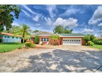 Brick house with a two-car garage and landscaped yard at 222 W Wall St, Frostproof, FL 33843