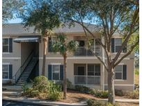 Attractive two-story condo building with balconies, palm trees, and lush landscaping at 5011 Hemingway Cir # 5011, Haines City, FL 33844