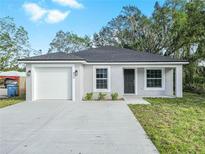 Newly constructed one-story home with a white garage door and landscaping at 815 S Seminole Ave, Fort Meade, FL 33841