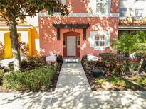 Pink house exterior with walkway and landscaping at 8425 Crystal Cove Loop, Kissimmee, FL 34747