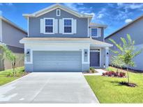 Two-story house with gray siding, white trim, and a two-car garage at 1413 Leamington Ln, Winter Haven, FL 33884