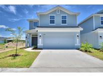 Two-story house with light gray siding, two-car garage, and landscaping at 1484 Leamington Ln, Winter Haven, FL 33884