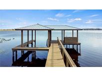 Wooden dock with covered seating area on the lake at 274 Paradise Island Dr, Haines City, FL 33844