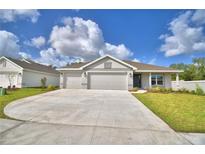 New single-story home with a two-car garage and landscaped yard at 5500 Knights Landing Dr, Lakeland, FL 33810