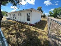 White house exterior with a yard and chain link fence at 143 D St, Lake Wales, FL 33853