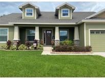Two story house with a green exterior, large front yard, and a stone accented porch at 2875 Creeks Crossing Blvd, Lakeland, FL 33810