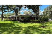 Brick ranch house with covered porch and large yard at 7520 Kathleen Rd, Lakeland, FL 33810