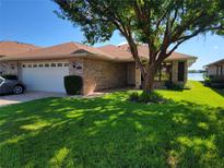 Brick house with a two-car garage and a well-maintained lawn at 727 Martinique Cir, Lakeland, FL 33803