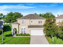 Two-story house with a two-car garage and landscaped yard at 141 Minniehaha Cir, Haines City, FL 33844
