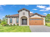 One-story home with a two-car garage and attractive landscaping at 574 Loblolly Pl, Auburndale, FL 33823