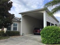 House with carport and a red SUV parked inside at 323 Travelers Dr, Polk City, FL 33868