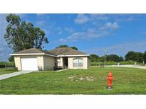 One-story home with attached garage and a well-maintained lawn at 522 Raymond Ave, Frostproof, FL 33843