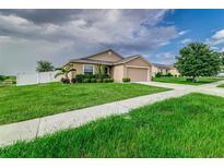 Tan one-story house with a two-car garage at 653 Hidden Lakes Ct, Haines City, FL 33844