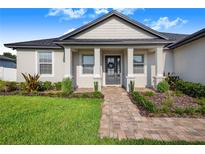 One-story home with gray roof, light beige walls, and a walkway leading to the front door at 5017 Ridgefield Lane, Lakeland, FL 33812
