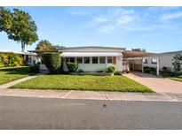 Single-wide mobile home with carport and well-maintained lawn at 619 Cassandra Ln, Lakeland, FL 33809