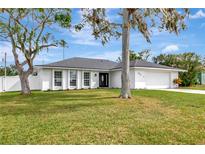 Ranch-style house with a white exterior and modern garage door at 4618 Crestview Ln, Lakeland, FL 33813