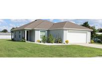 One-story home with gray siding, white garage door, and well-manicured lawn at 517 S Perry Ave, Fort Meade, FL 33841