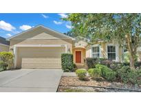 Tan house with two-car garage and manicured landscaping at 6838 Glenbrook Dr, Lakeland, FL 33811