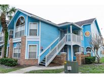 Light blue two-story condo building with brick accents and stairs at 2741 N Poinciana Blvd # 43, Kissimmee, FL 34746