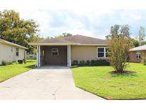 Tan single-story house with carport and well maintained lawn at 608 Lark Dr, Lakeland, FL 33813