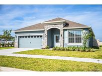 One-story home with gray exterior, stone accents, and a two-car garage at 731 Griffon Ave, Lake Alfred, FL 33850