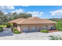 House exterior showcasing a two-car garage and landscaping at 3933 Mammoth Grove Rd, Lake Wales, FL 33898